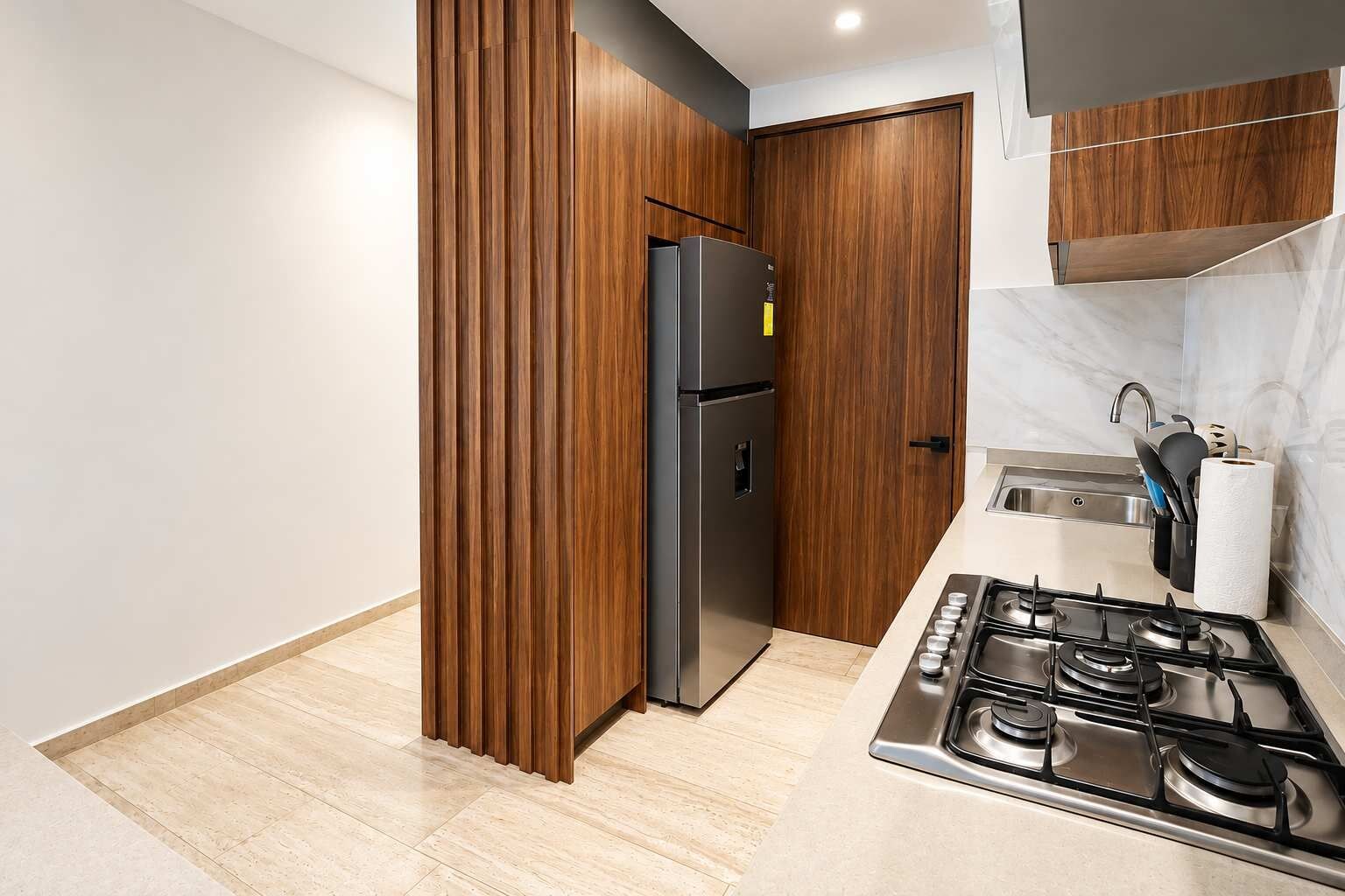 Cocina abierta y totalmente equipada con electrodomésticos modernos, ideal para preparar tus comidas como en casa.