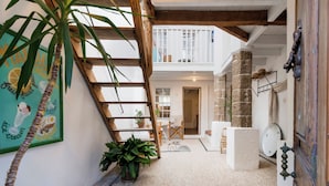 Un interior acogedor con una escalera de madera, un comedor y vistas al exterior.