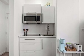 A compact kitchenette with a microwave, sink, and a small coffee maker. - Condado Gem Perfect City Escape Walk to Beach (San Juan)
