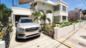 Una casa moderna con entrada para coches y un coche aparcado.