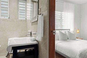 A bathroom with a white sink, mirror, and towel rack. - Piccioni Retreat Spacious 2BR 2BA in Condado (San Juan)