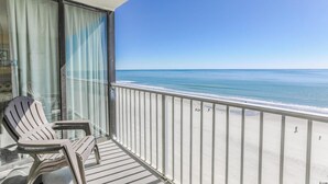 A balcony with a view of the ocean, a chair, and a glass door. - 🌟Oceanfront~Awesome Amenities~ Sands Beach Club 722🌟 (Myrtle Beach)