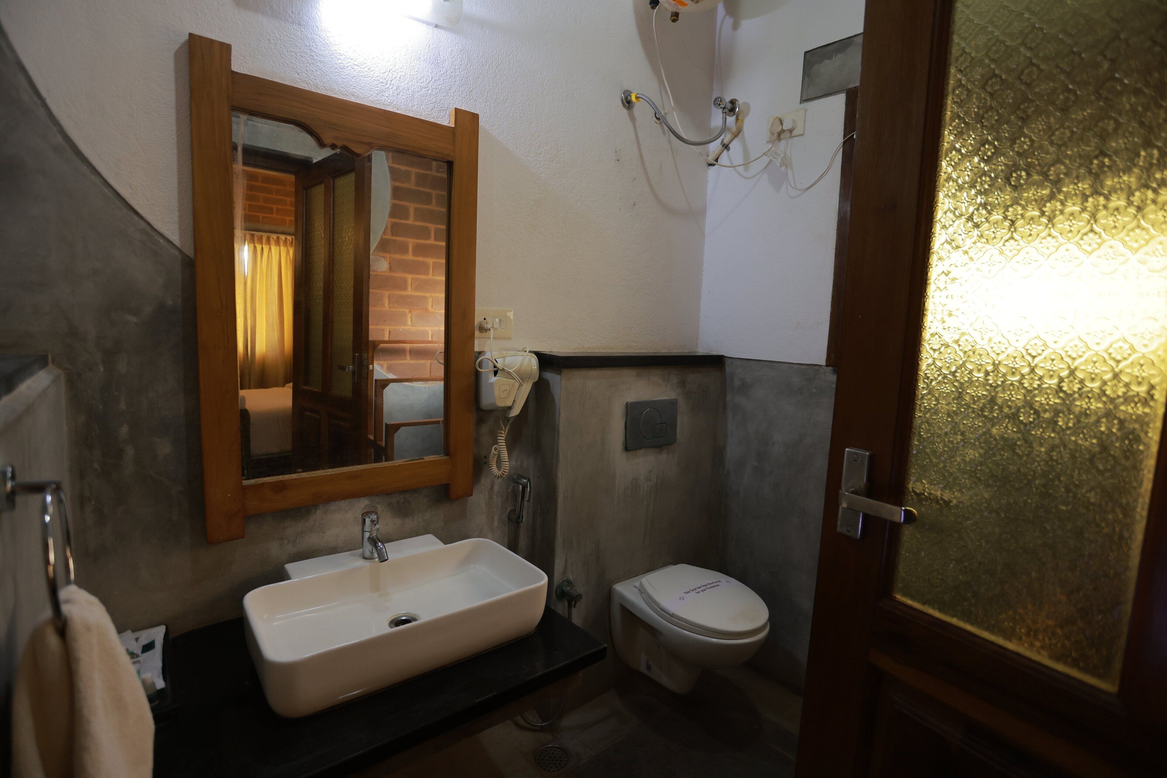 Un baño con lavamanos, inodoro y espejo.