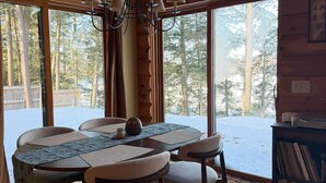 Ein Holzinterieur mit einem runden Esstisch, Stühlen und einer Chandelier.