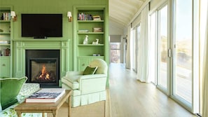 A living room with a fireplace, bookshelves, a television, and a view through large sliding glass doors. - Magnolia at Franklin Vale Retreat (Mount Franklin)
