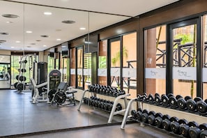 Ein Fitnessstudio mit Krafttrainingsgeräten, Hanteln und Trainingsmaschinen.