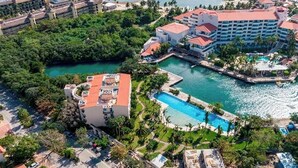 A resort with multiple buildings, a large pool, and a marina. - Private Jacuzzi | Canal View Terrace (Puerto Aventuras)