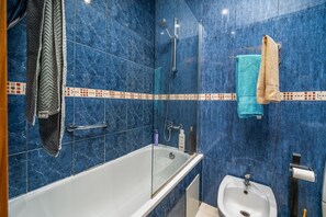 Ein Badezimmer mit Badewanne, Dusche und Waschbecken, alles mit blauen Marmorfliesen.