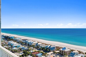 Ein Küstenort mit Strandhäusern, blauem Himmel und Sandstrand.