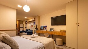 A hotel room with a bed, a desk, a TV, and a wardrobe. - Cozy apartment in a modern building in the heart of Rio, accommodates up to 6 people. (Rio de Janeiro)