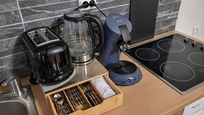 A kitchen with a toaster, coffee maker, kettle, and induction cooktop.