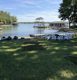 Une jetée au bord du lac avec des bateaux, un kiosque et un bâtiment doté d’une terrasse.
