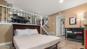 Ein Schlafzimmer mit einem großen Bett, einer Treppe, einem Kleiderschrank und einer Lampe.