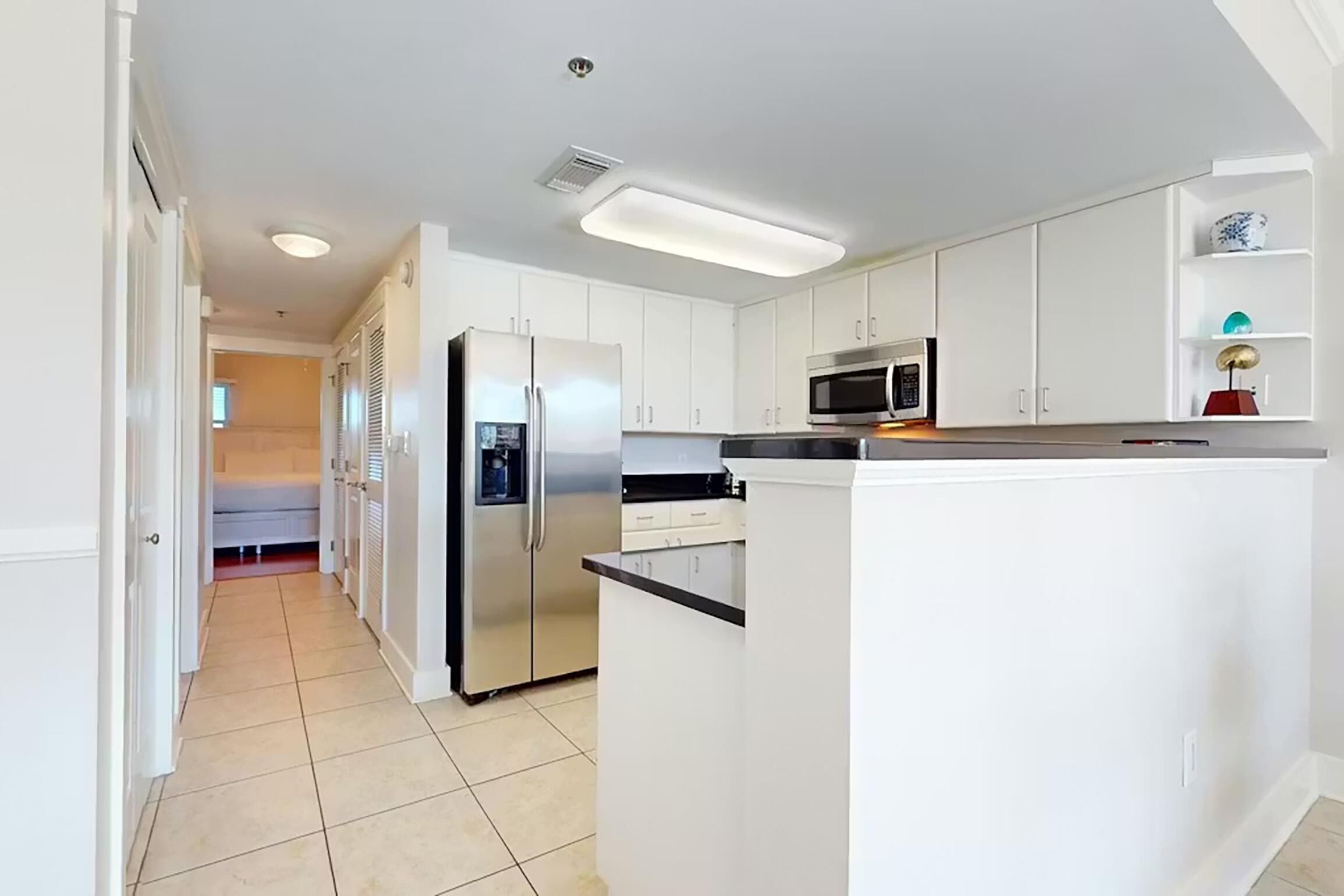 A modern kitchen with white cabinets, stainless steel appliances, and a central island.