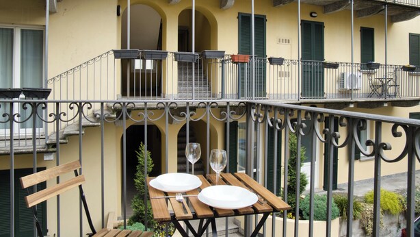 Ein Balkon mit Tisch für zwei Personen, zwei Weingläsern und einem Stuhl.