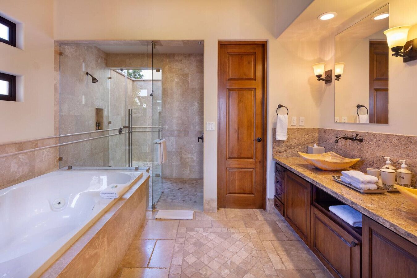 Une salle de bain moderne dotée d’une douche à parois de verre, d’une baignoire sur pieds et d’un meuble-lavabo avec un grand évier et un grand miroir.