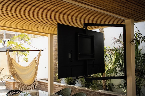 A hammock, a TV, and outdoor seating.