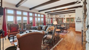 Un salón amplio con chimenea, ventanas grandes y vistas al exterior.