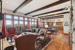 A spacious living room with a fireplace, large windows, and a view of the outdoors. - LUX Lodge - Sauna, Chef Kitchen+ Long Range Views! (Banner Elk)