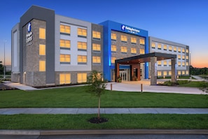 A Holiday Inn Express hotel with a modern design, featuring a prominent entrance and a well-maintained lawn. - Holiday Inn Express & Suites Overland Park South (Overland Park)