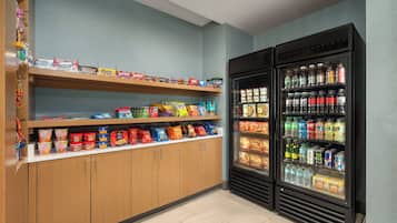 Un'area espositiva per snack e bevande, con scaffali e un frigorifero.