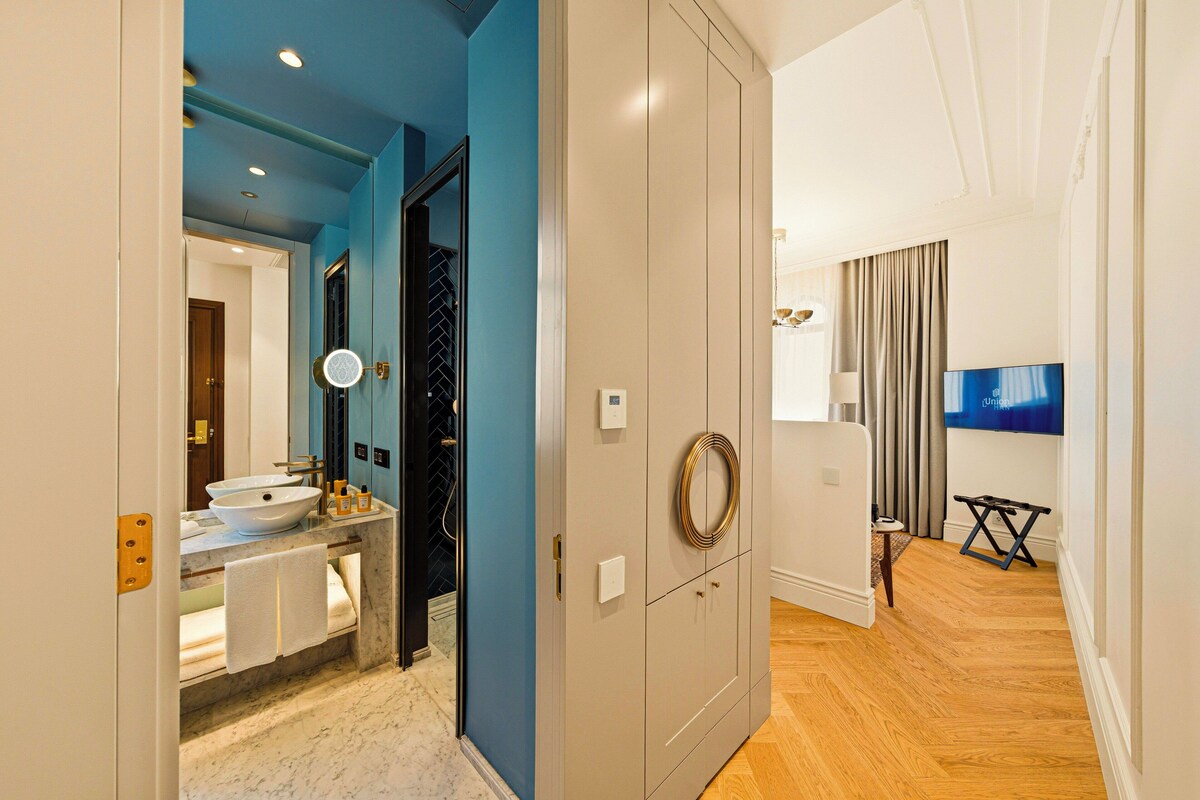 A modern bathroom with a sink, mirror, and towel rack.