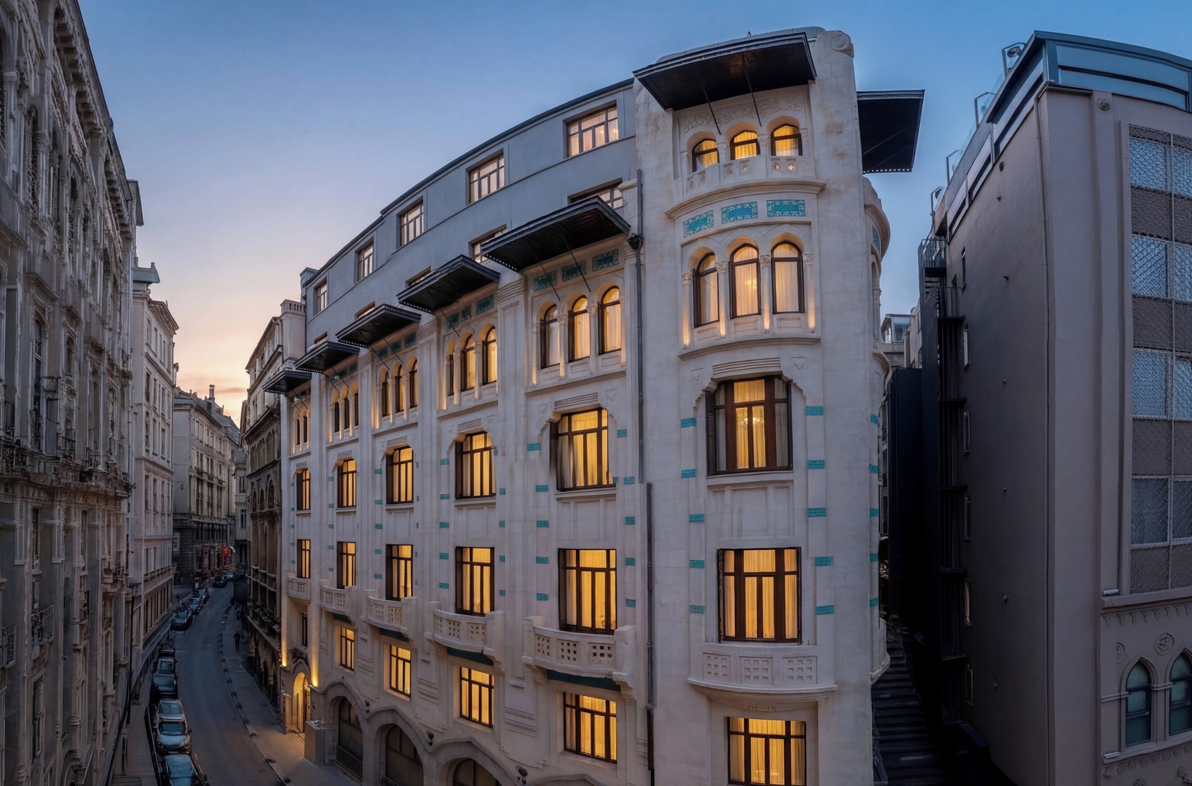 Un edificio a più piani con finestre ad arco e balconi, una strada stretta e una scala che conduce a un livello superiore.