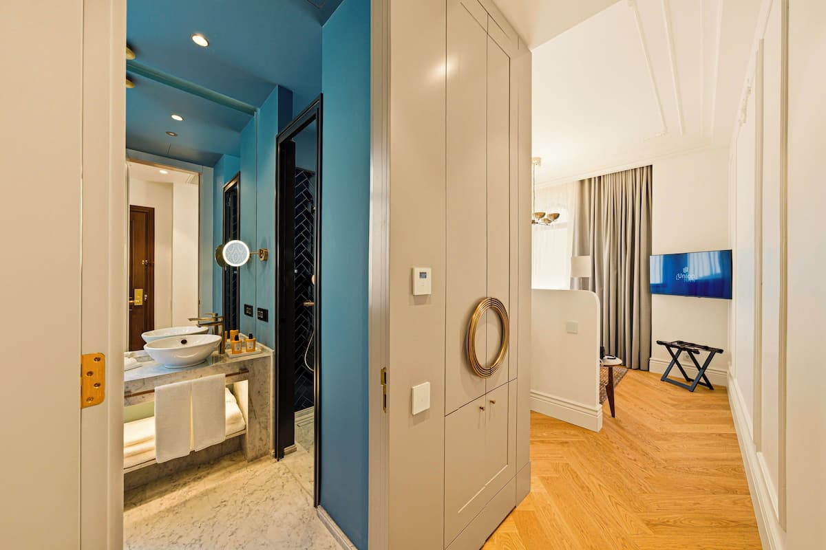 A modern bathroom with a sink, mirror, and towel rack.