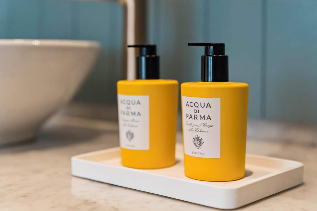 Two yellow bottles of body lotion on a white tray.