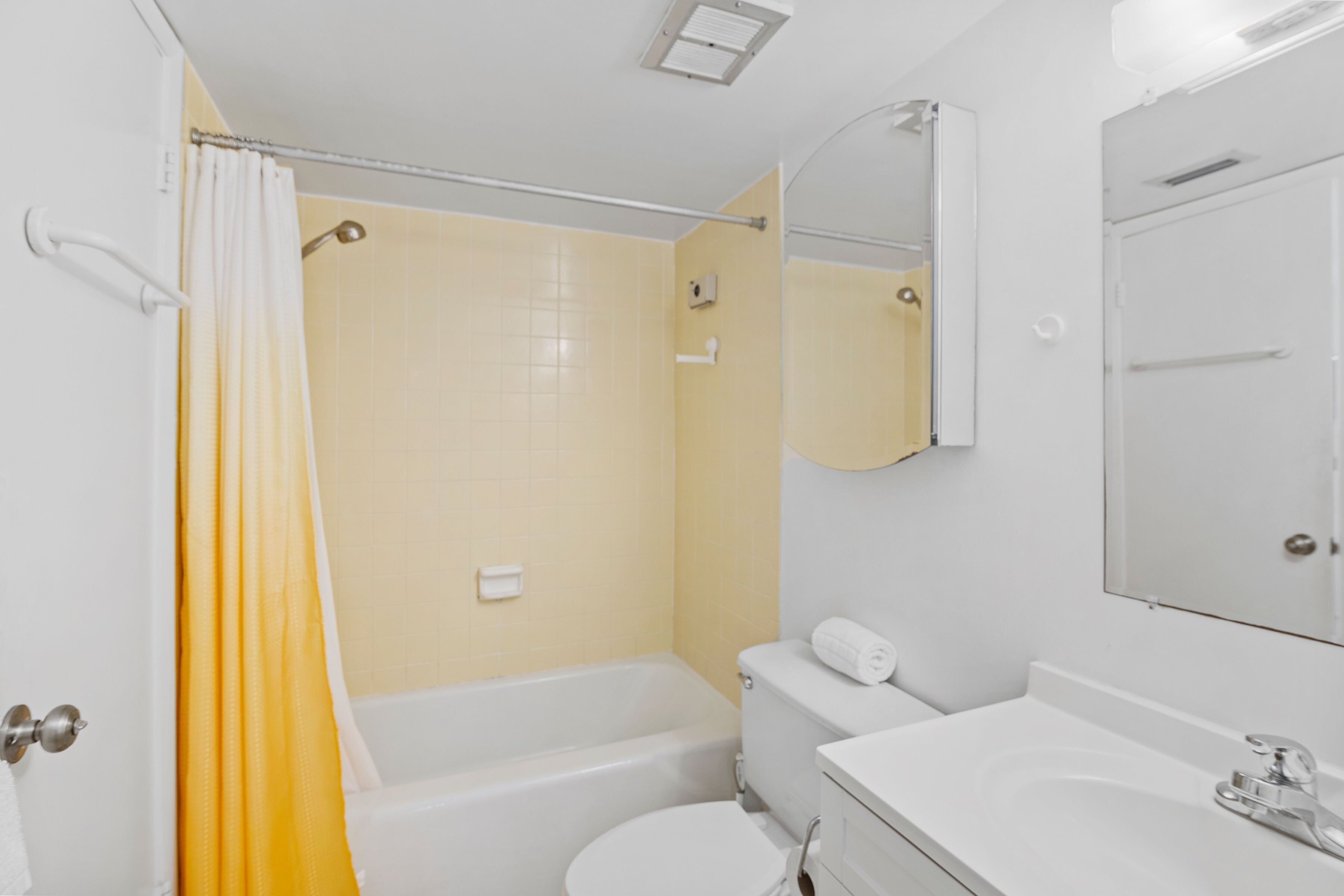 A bathroom with a bathtub, toilet, and sink.
