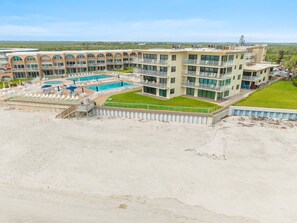 A multi-story hotel with a pool, balconies, and a beach area. - Seaward D-102 (New Smyrna Beach)