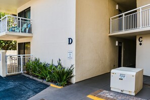 A building with a loading zone sign, a white utility box, and a balcony with a railing. - Seaward D-102 (New Smyrna Beach)