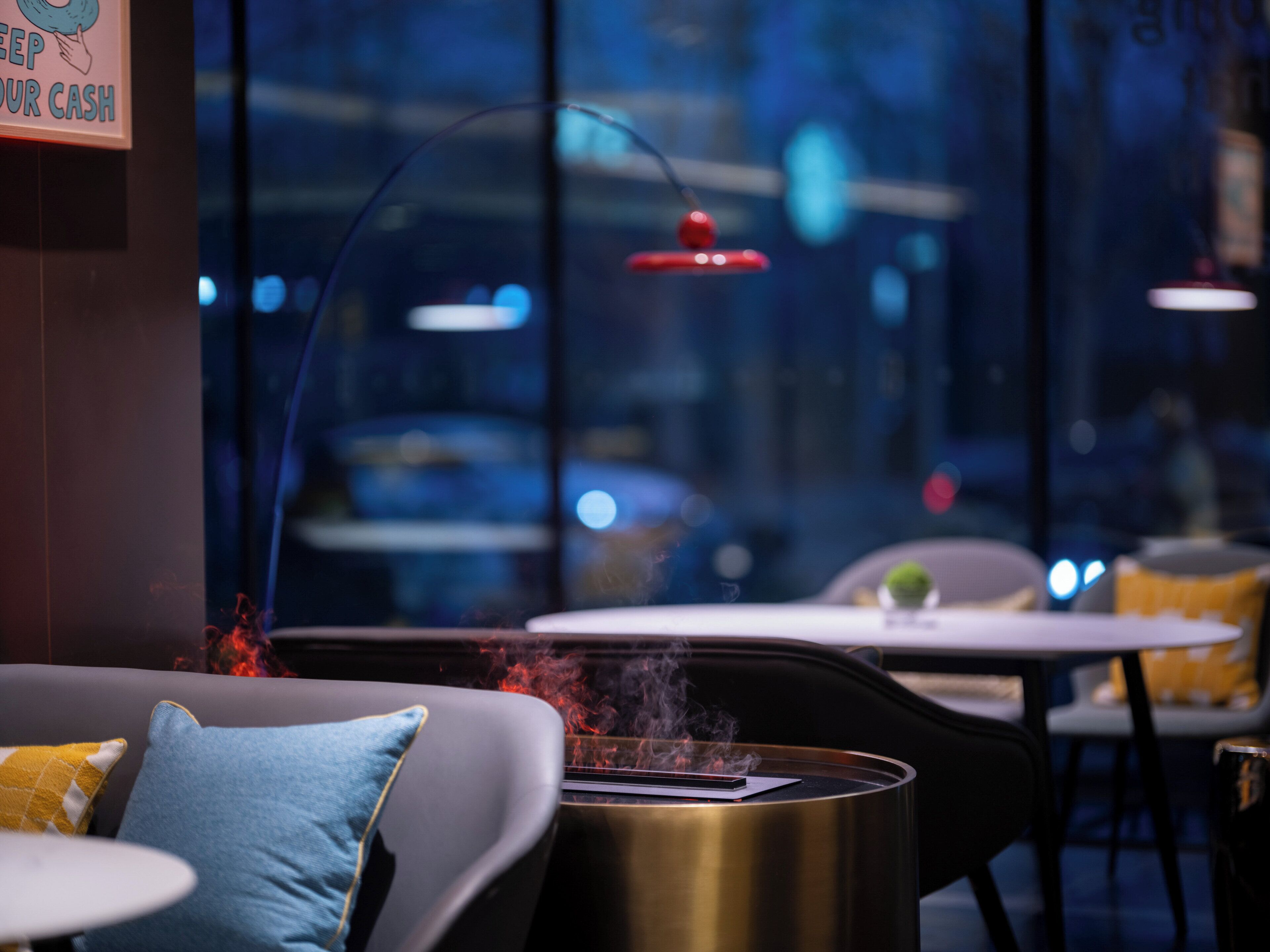 A modern indoor setting with a sofa, a table with a smartphone, and a decorative element emitting smoke.