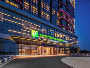 Un moderno edificio de hotel con un cartel llamativo que indica 'Holiday Inn Express'.