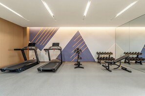 A gym with treadmills, a stationary bike, and a bench press.