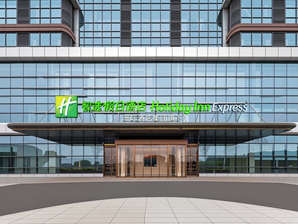 A Holiday Inn Express hotel with a modern glass facade and a prominent green and white logo.
