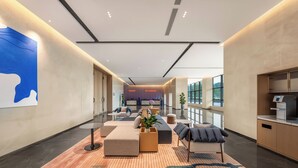 Un hall d’entrée moderne doté d’espaces de détente, d’un comptoir d’accueil et de grandes fenêtres.