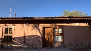 Un bâtiment rustique avec une porte en bois, une fenêtre et des fondations en pierre.