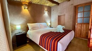 Une chambre à coucher avec un lit, des lampes de chevet, une table de chevet en bois et une porte en bois.