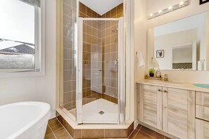A modern bathroom with a glass shower enclosure, a bathtub, a vanity with a mirror, and a view of the outside. - Modern Luxury 5 ⭐ Space near Brampton | Sleeps 8 (caledon)