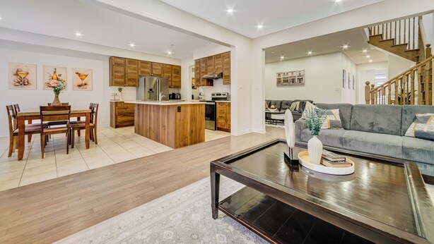 A modern kitchen with wooden cabinets, a central island, and a dining area with a wooden table and chairs. - Modern Luxury 5 ⭐ Space in Caledon| Sleeps 8 (caledon)