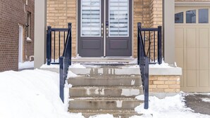 A two-story building with a double door entrance, a brick facade, and a garage door. - Modern Luxury 5 ⭐ Space in Caledon| Sleeps 8 (caledon)