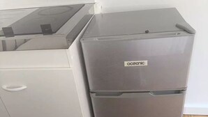 Eine kleine Küche mit einem weißen Kühlschrank und einem einbaufertigen Backofen.