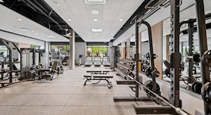 A modern gym with various exercise equipment, including treadmills, weight machines, and free weights. - Landing | Beautiful 2BD, Gym (Seattle)