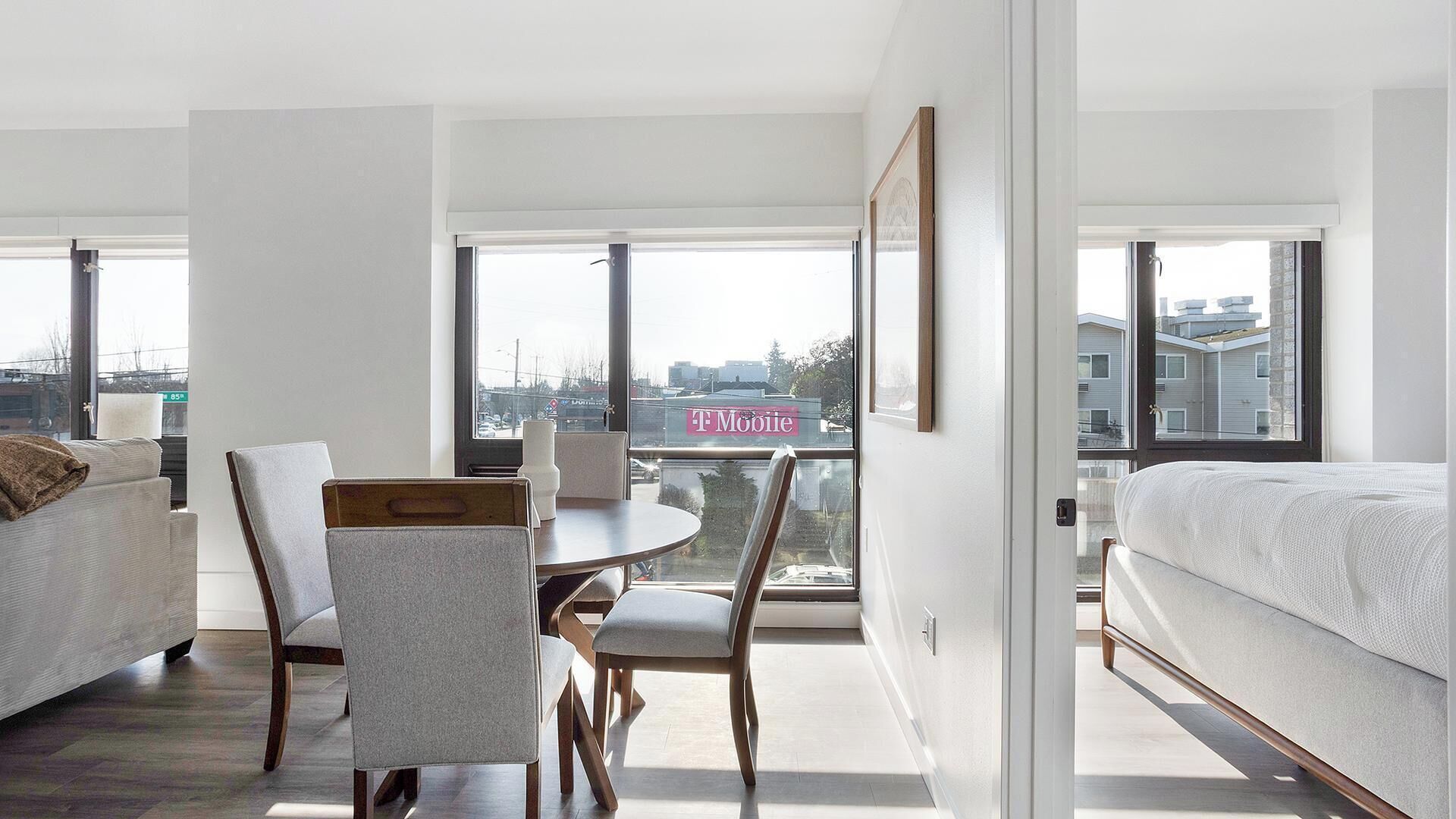 Une chambre d’hôtel moderne dotée d’une grande fenêtre, d’une table à manger, d’un canapé et d’un lit.