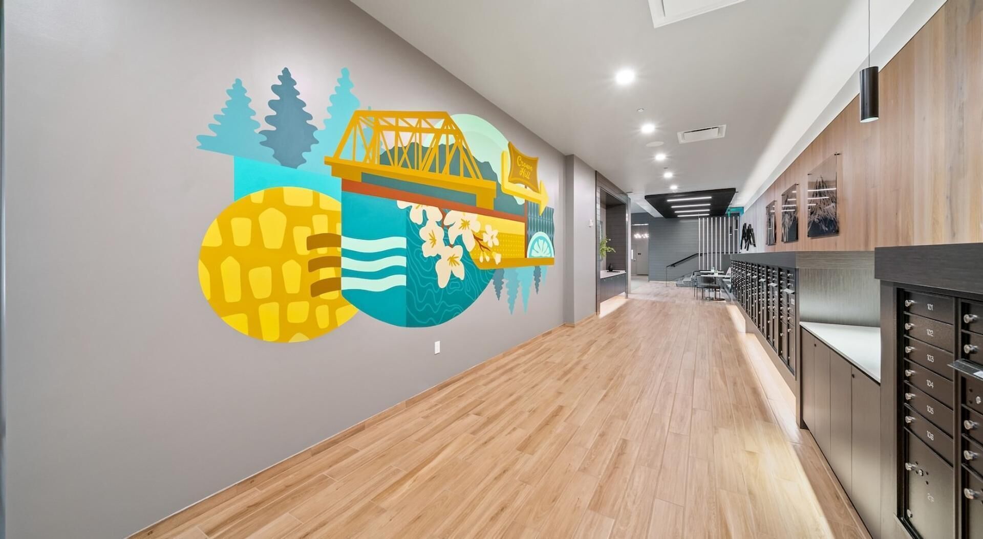 Un couloir d’hôtel avec un plancher en bois et une fresque murale représentant un pont, des arbres et un bâtiment.