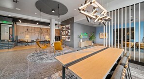 A modern interior with a long wooden table, hanging chairs, and a unique ceiling light fixture. - Landing | Stunning 1BD, Gym (Seattle)