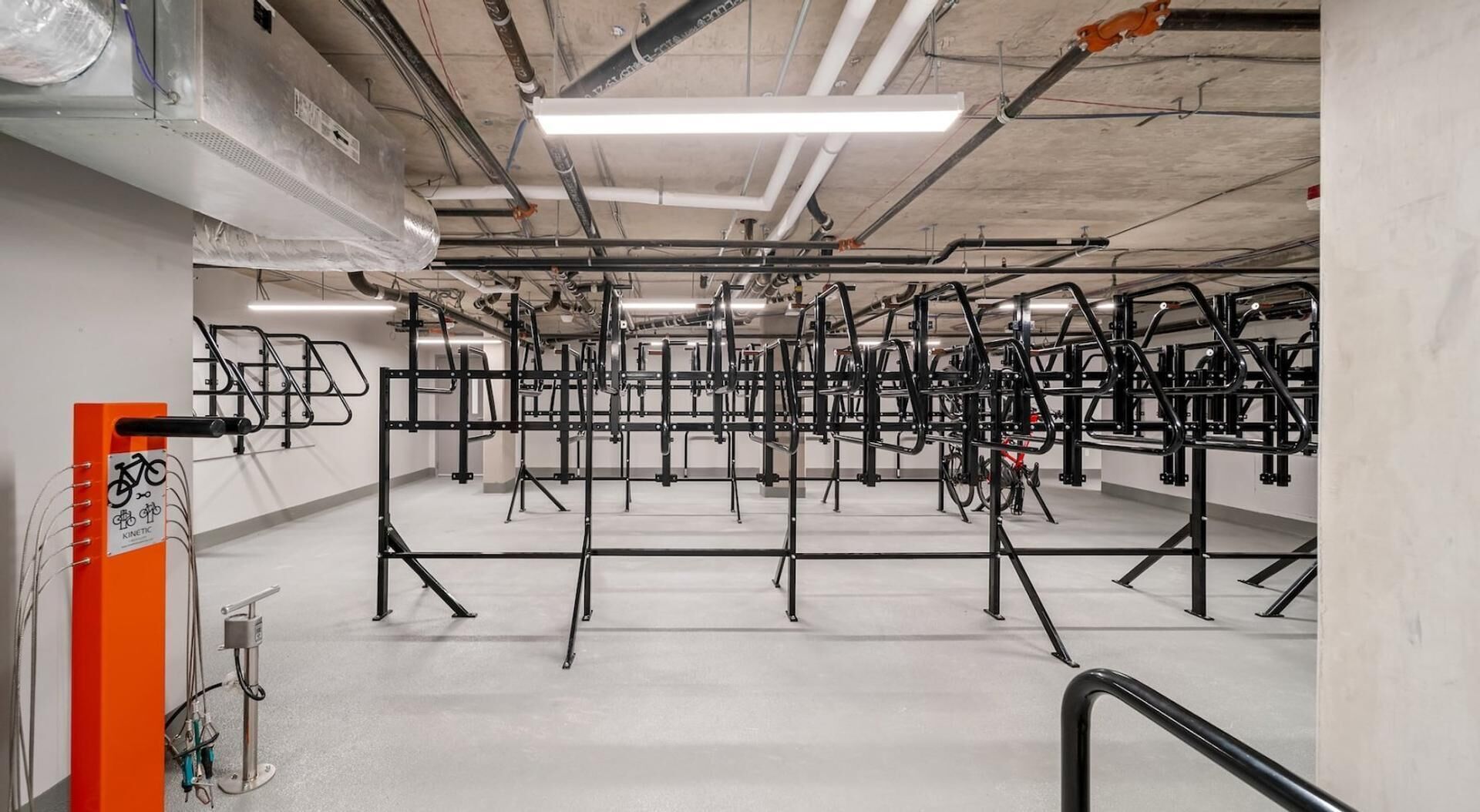 Un gimnasio con varias estaciones de ejercicio y un soporte para bicicletas.