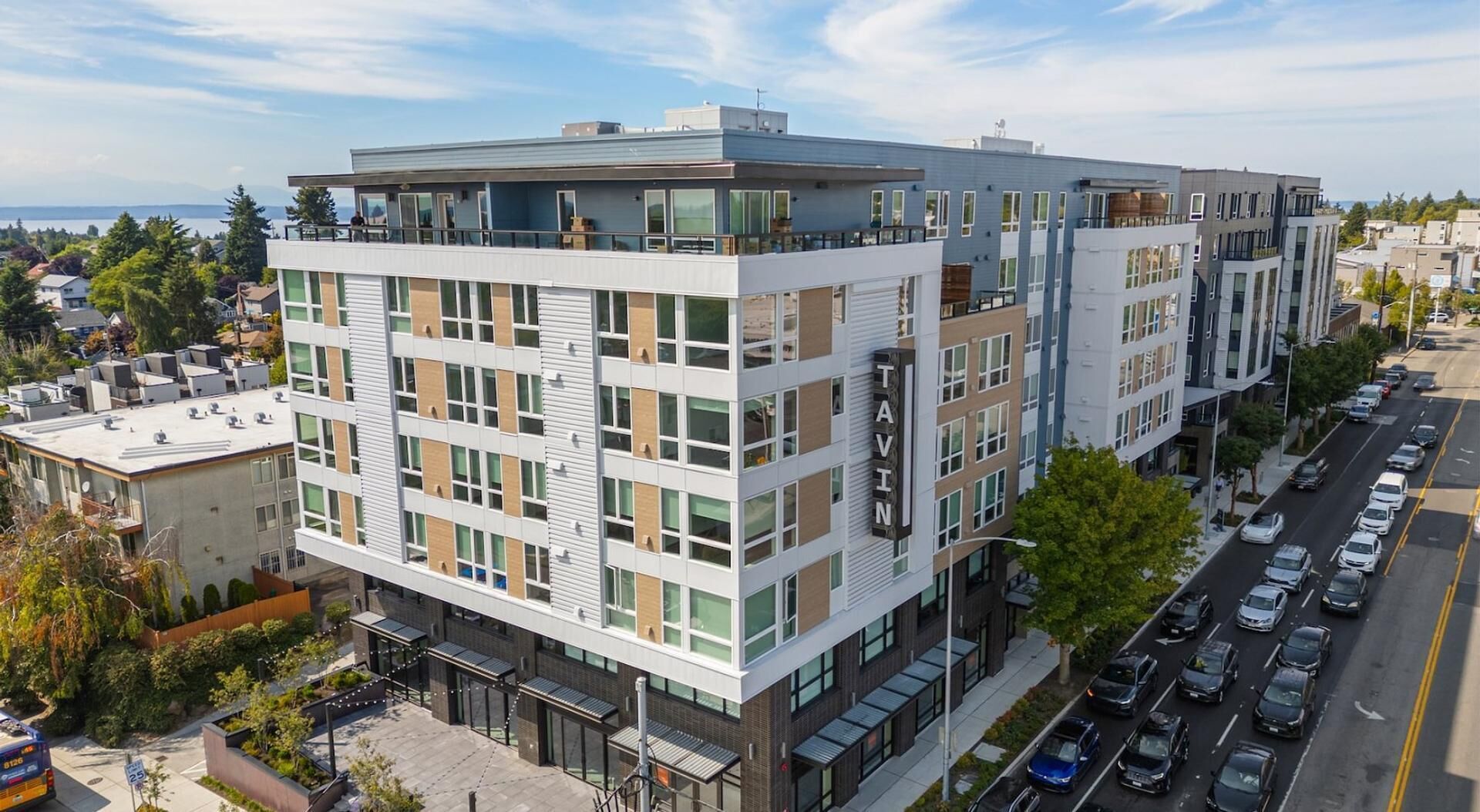 A modern multi-story building with a flat roof, large windows, and a mix of brick and glass facades.