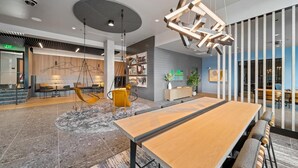 Un interior moderno con una larga mesa de madera, sillas colgantes y una lámpara de techo original.
